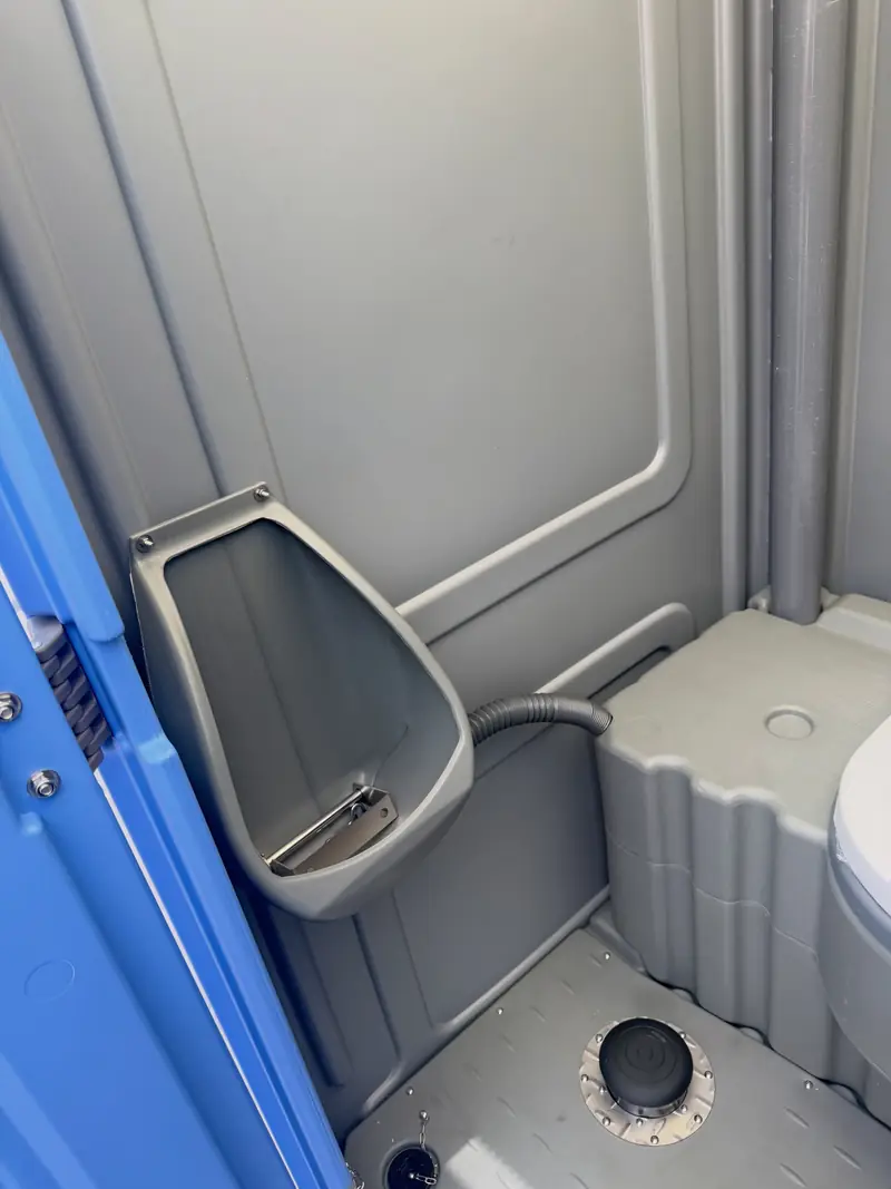 Urinal mounted inside a standard porta potty