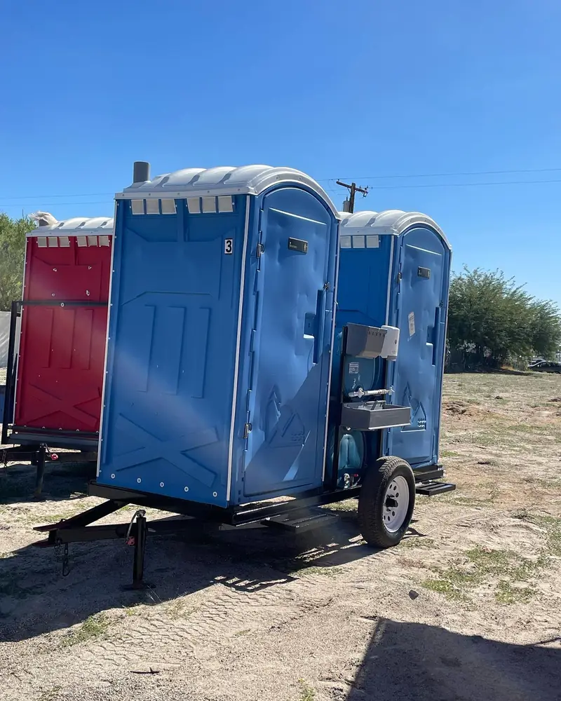 Standard porta potty mounted on a small towable trailer for moving work crews