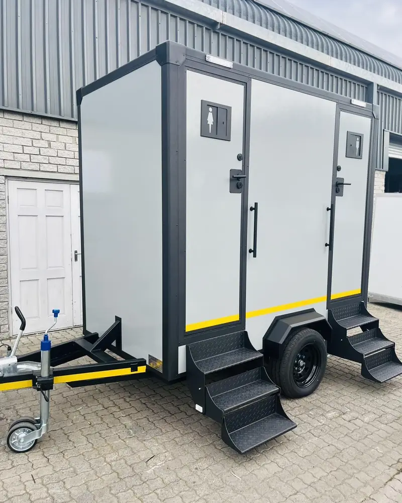 Two-stall restroom trailer with separate men and women doors and fold-down steps